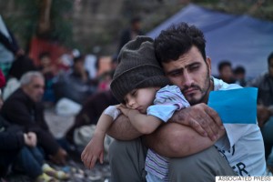 FILE - In this Sunday, Oct. 4, 2015 file photo, a Syrian refugee child sleeps in his father's arms while waiting at a resting point to board a bus, after arriving on a dinghy from the Turkish coast to the northeastern Greek island of Lesbos. Bold ideas for helping Syrian refugees and their overburdened Middle Eastern host countries are gaining traction among international donors who were shocked into action by this year's migration of hundreds of thousands of desperate Syrians to Europe. (AP Photo/Muhammed Muheisen, File)